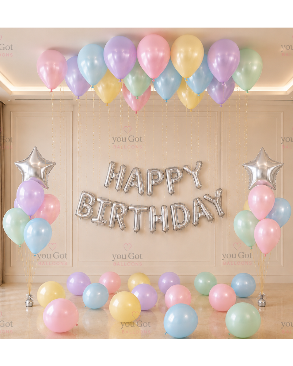 Pastel ceiling birthday balloon setup with silver star balloon bunches for Dubai celebrations
