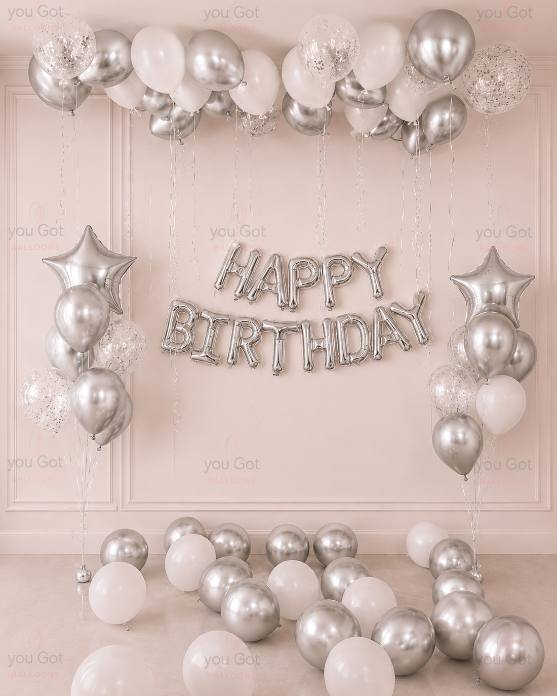 White and silver birthday ceiling balloon setup with Happy Birthday backdrop in Dubai